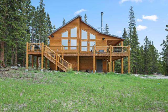 A mountain cabin with a deck among pine trees