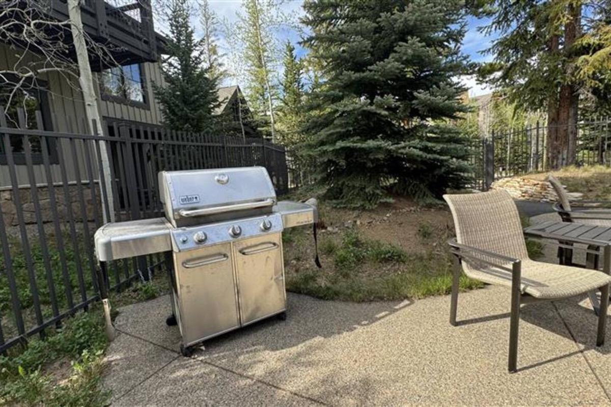 Gas grills and outdoor dining tables in the courtyard at Mountain Thunder Lodge