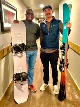 Josh Burton of Gilson Group and Jack Schumacher of Ski Butlers with a snowboard and a pair of skis